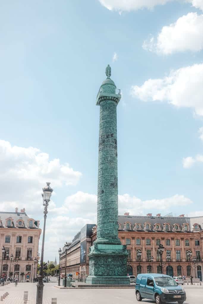 Famous bronze Vendome Column with Napoleon statue on top located on spacious old city square in Paris on sunny summer afternoon